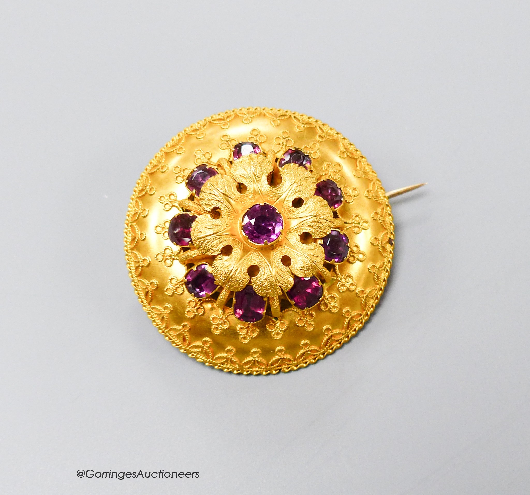 A Victorian yellow metal and ten stone garnet set cannetile work circular brooch, 39mm, gross 17.9 grams.